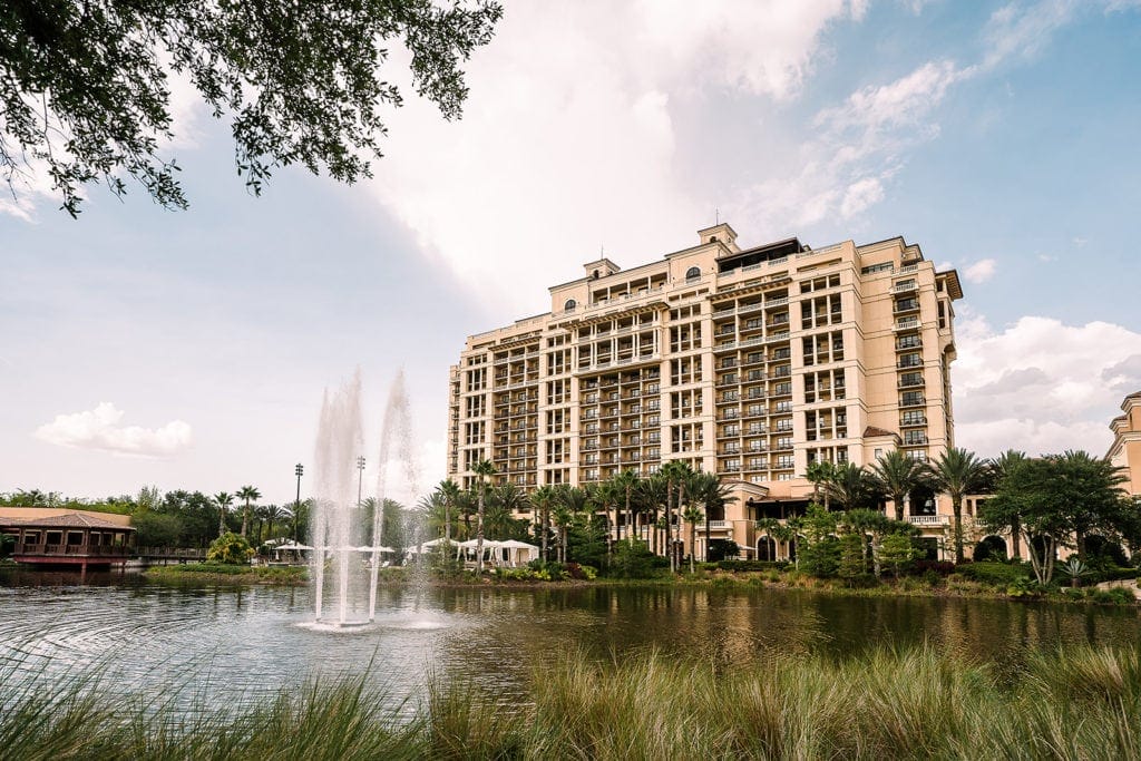 A breathtaking outdoor scene of the Four Seasons Orlando, featuring lush greenery, palm trees, and a pristine blue sky.