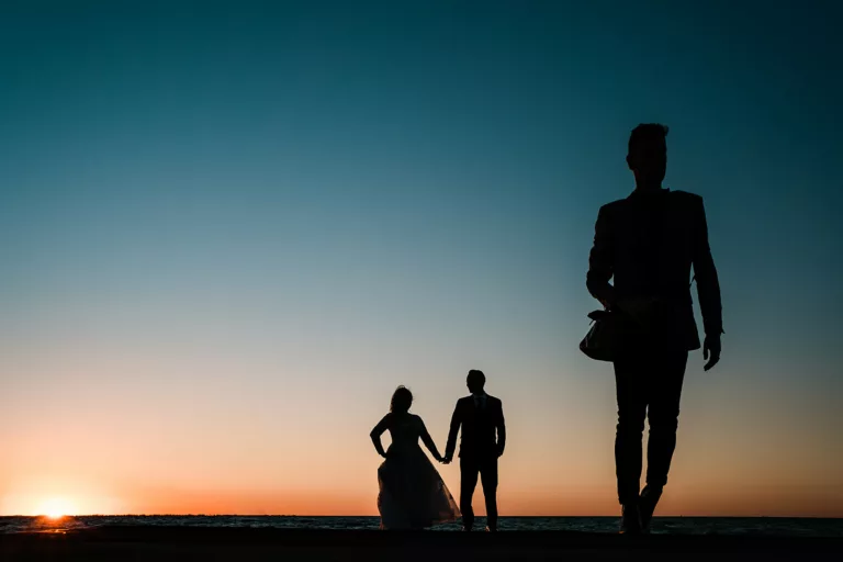 A sunset silhouette of a couple on their wedding day